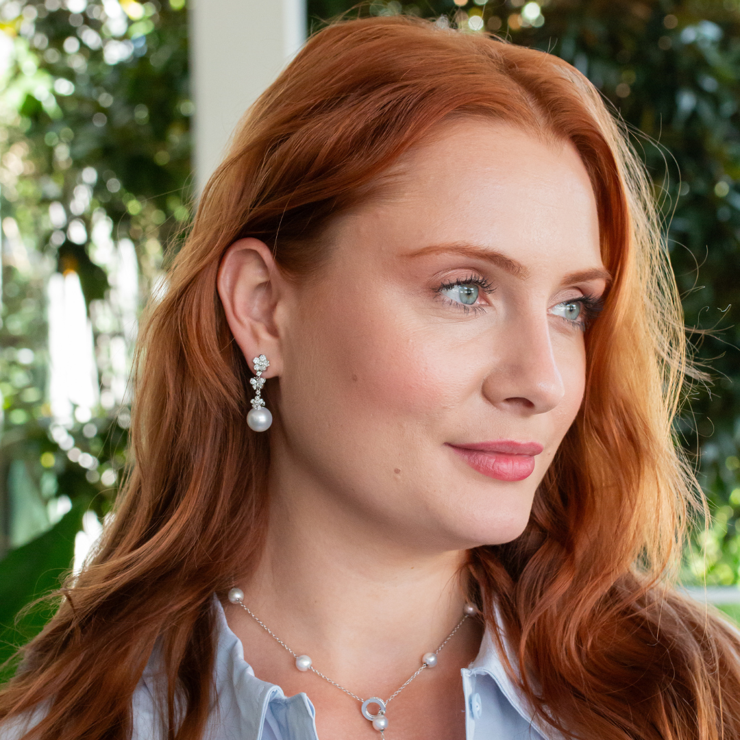 Close-up of a woman wearing Mikimoto pearl earrings, highlighting the elegant pearls and their lustrous shine.