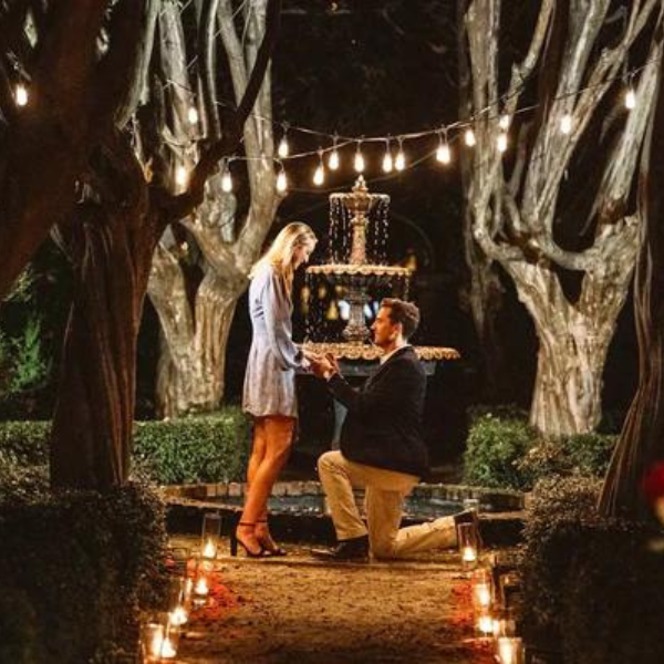 Proposal in backyard with string lights