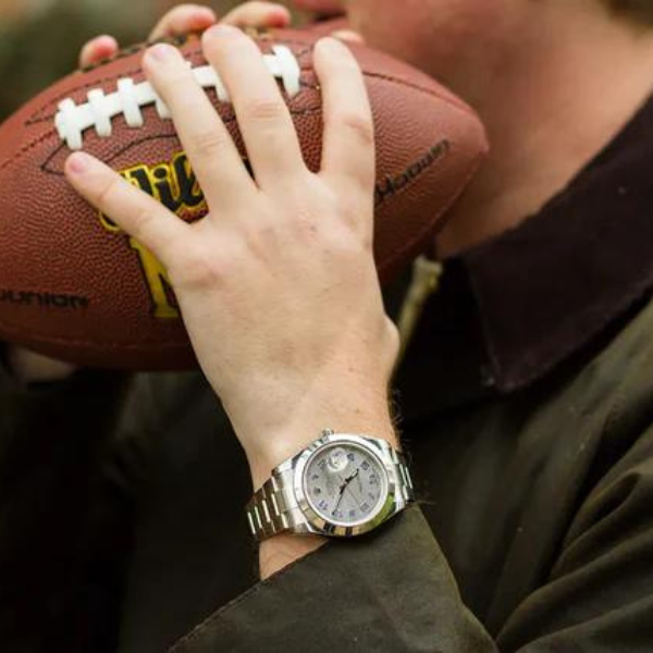 mens white gold watch holding football